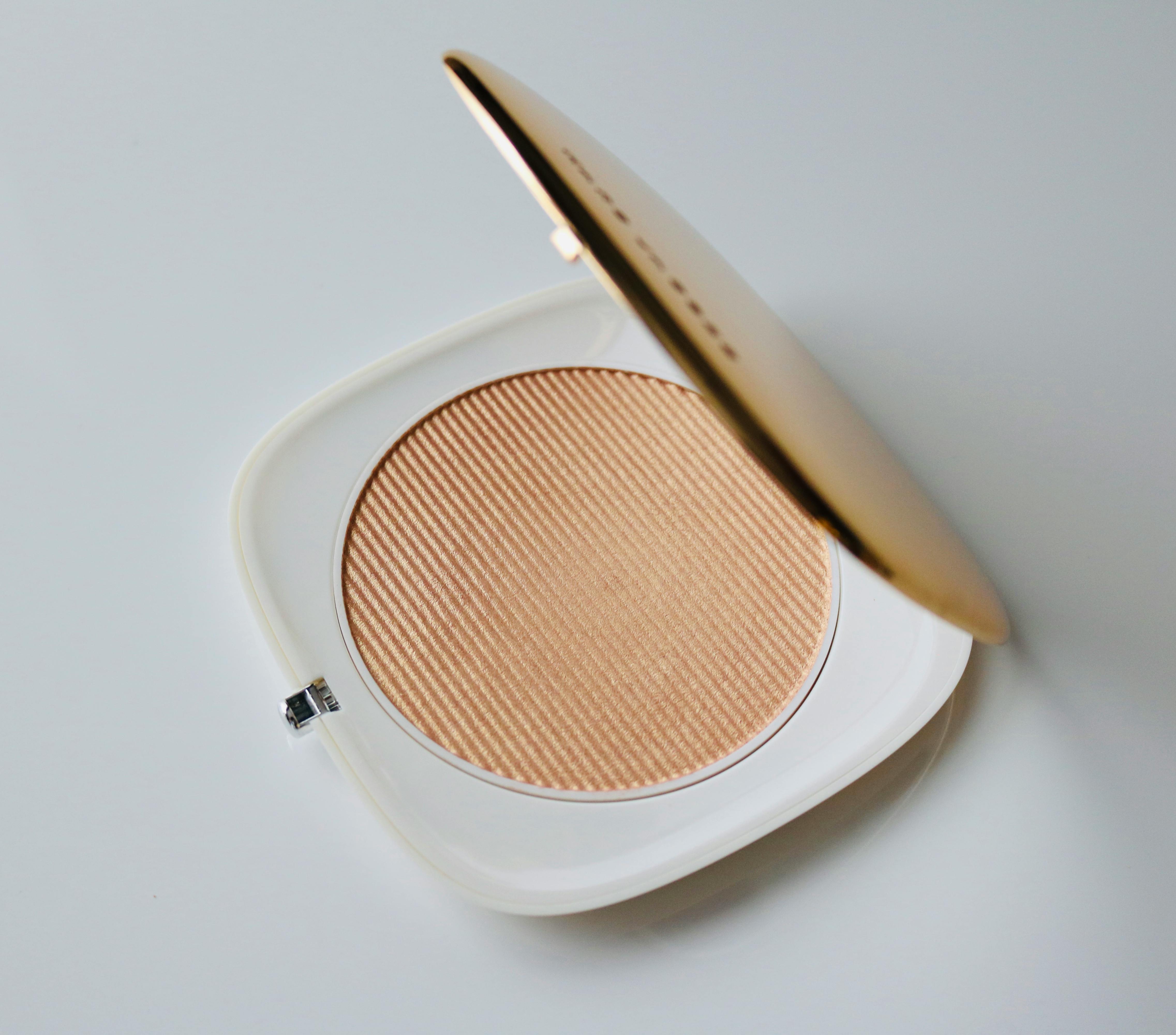 Open compact powder case with beige powder
